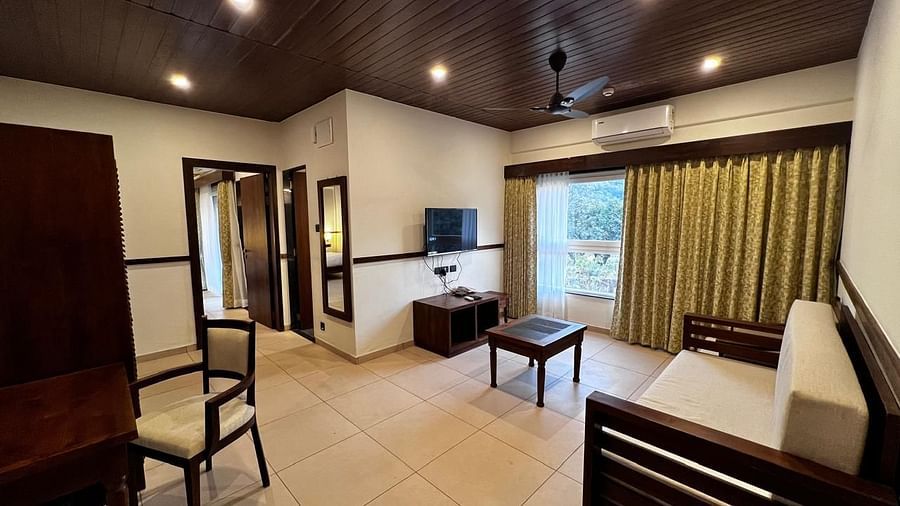 Grand Suite room with a spacious bed, seating area, desk, and a window with outdoor views at Mastiff Grand La Villae Resort, Lonavala